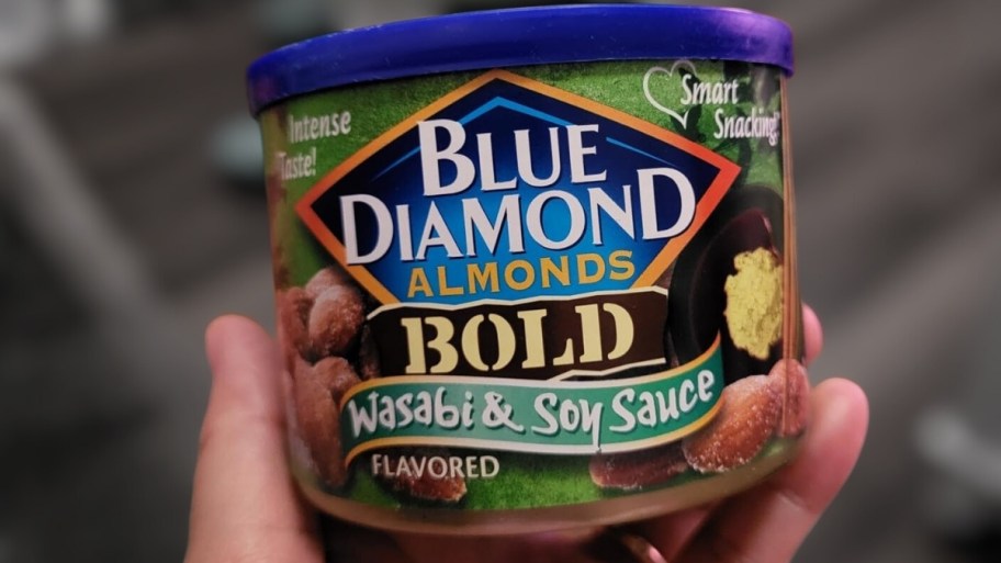 a hand holding a can of wasabi soy almonds
