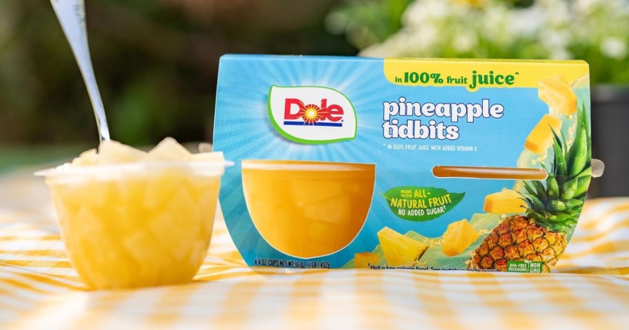 a Dole Pineapple Tidbits package and fruit bowl open with a spoon on it