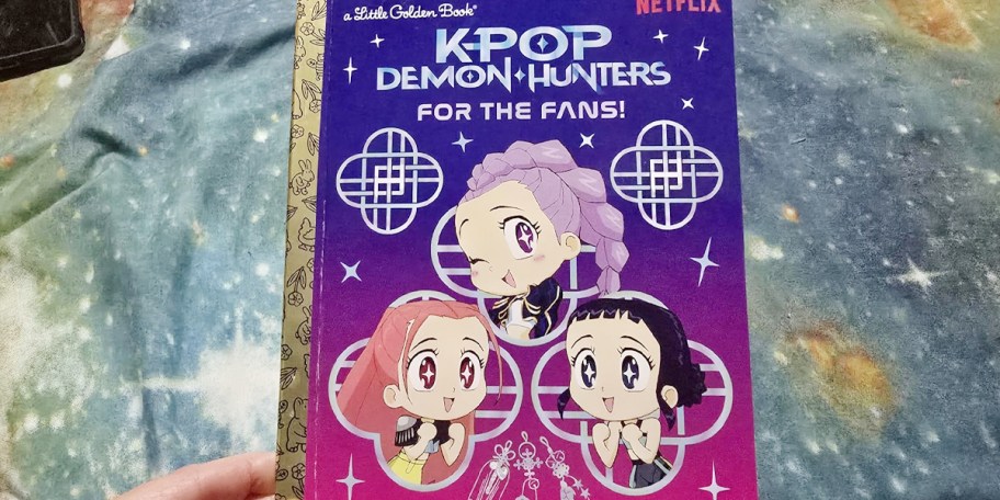 hand holding kpop demon hunters book 