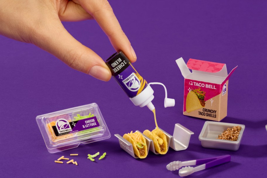 hands pinching mini taco sauce toy