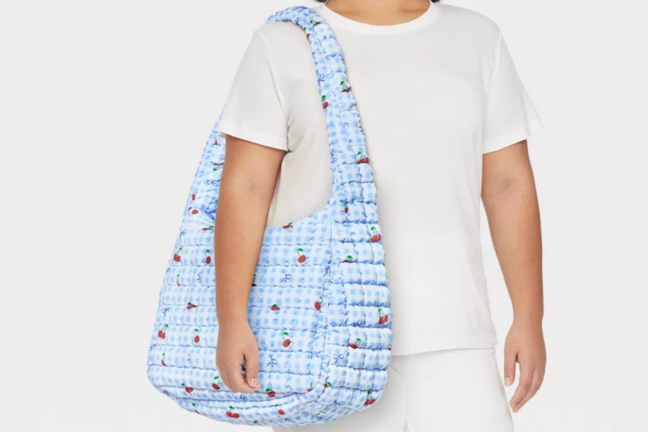 woman carrying blue gingham bag on shoulder