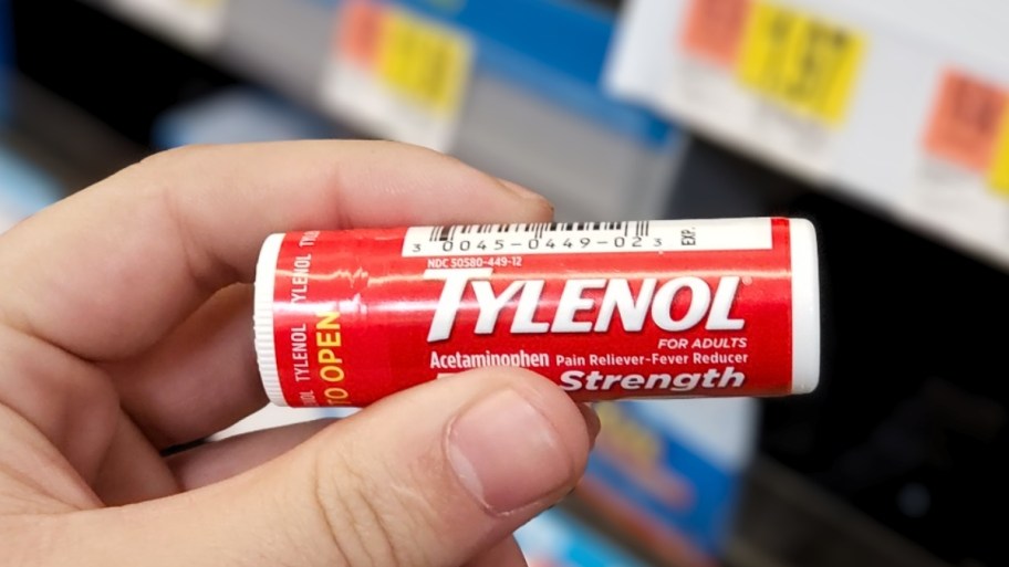 a mans hand holding an extra strength tylenol travel pack