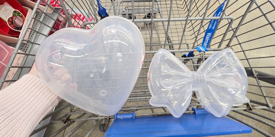 hand holding heart container with bow in cart 