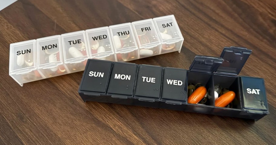 white and black weekly pill organizers on table