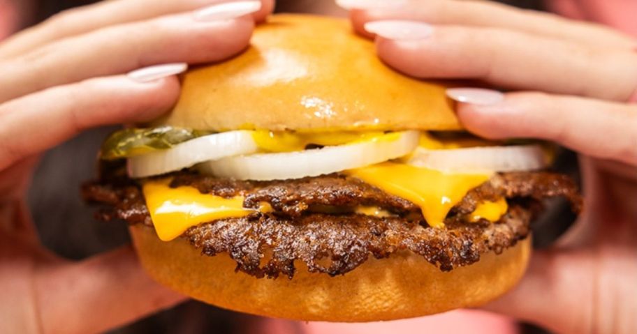 Hands holding a Freddy's Original Double Steakburger