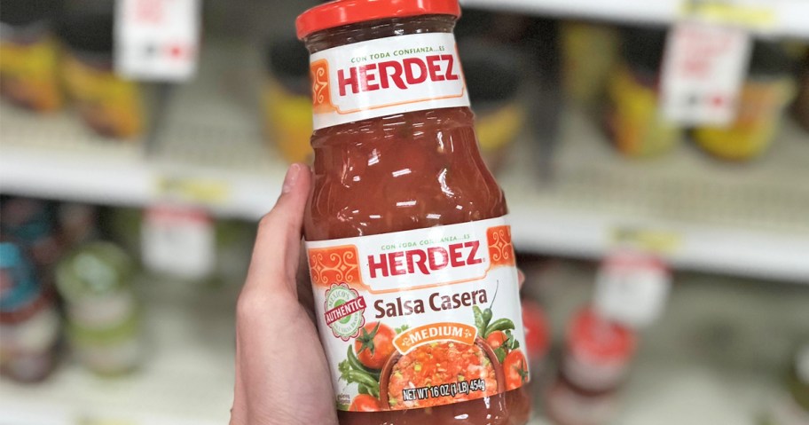 hand holding a jar of Herdez Salsa in store