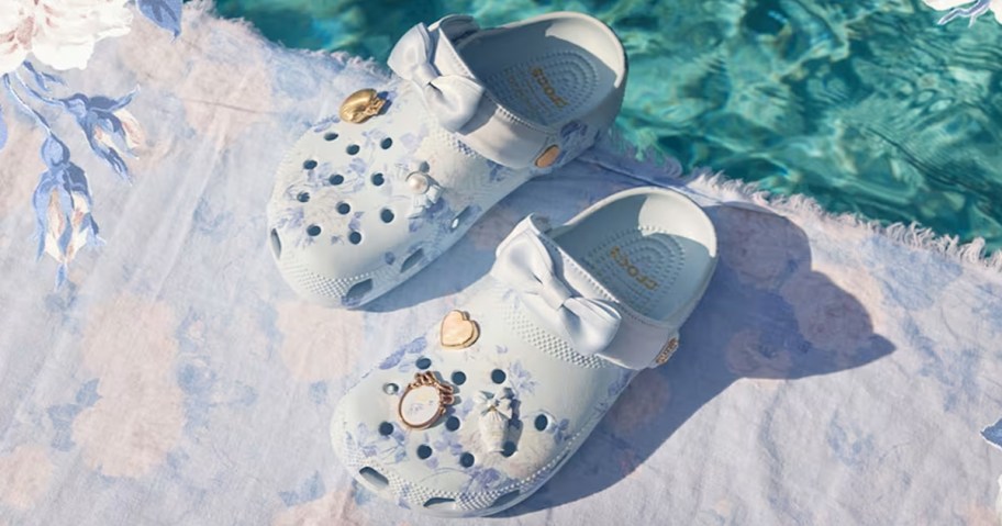 pair of blue crocs with bows and charms on them