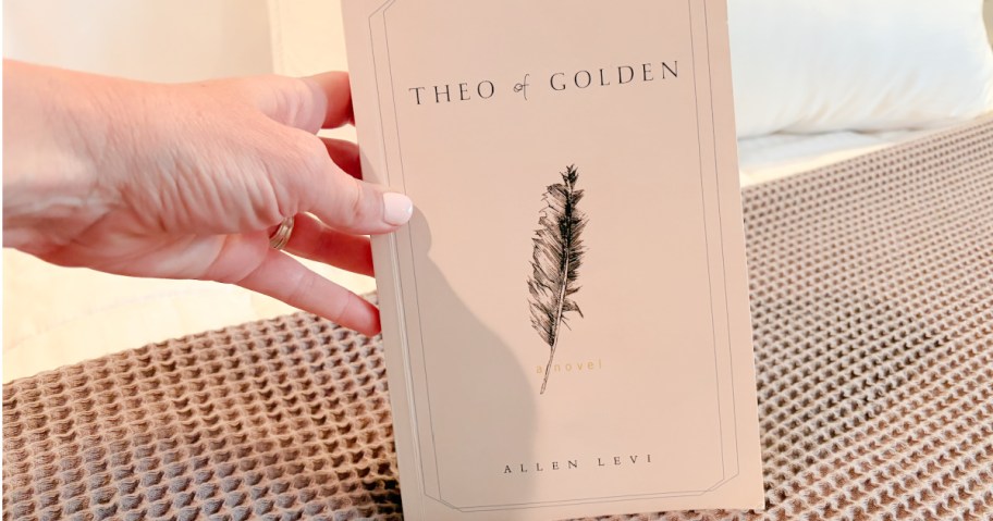 Hand holding Theo of golden book