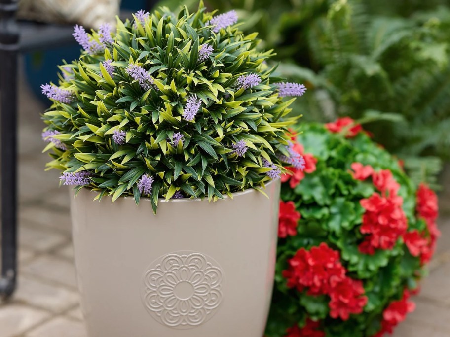 a faux plant in a planter with another faux plant beside it