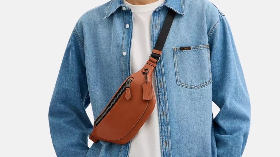 a man wearing a coach belt bag