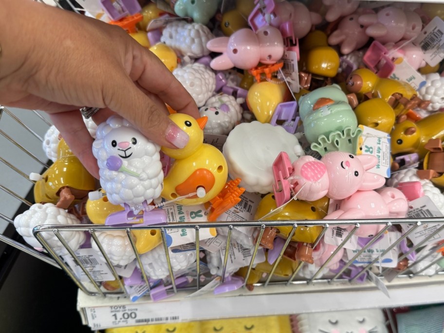 womans hand holding two easter windup toys