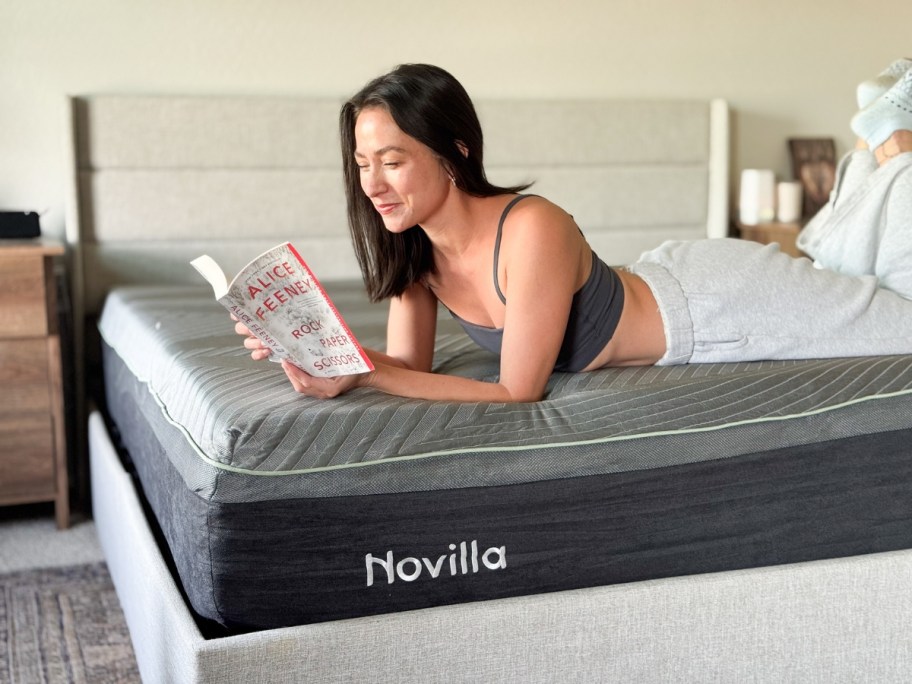 a woman laying on a Novilla mattress reading a book