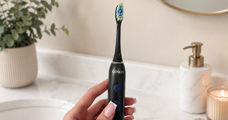 hand holding a black electric toothbrush
