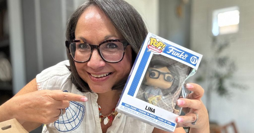 woman holding an pointing to a box with a personalized Funko Pop figure