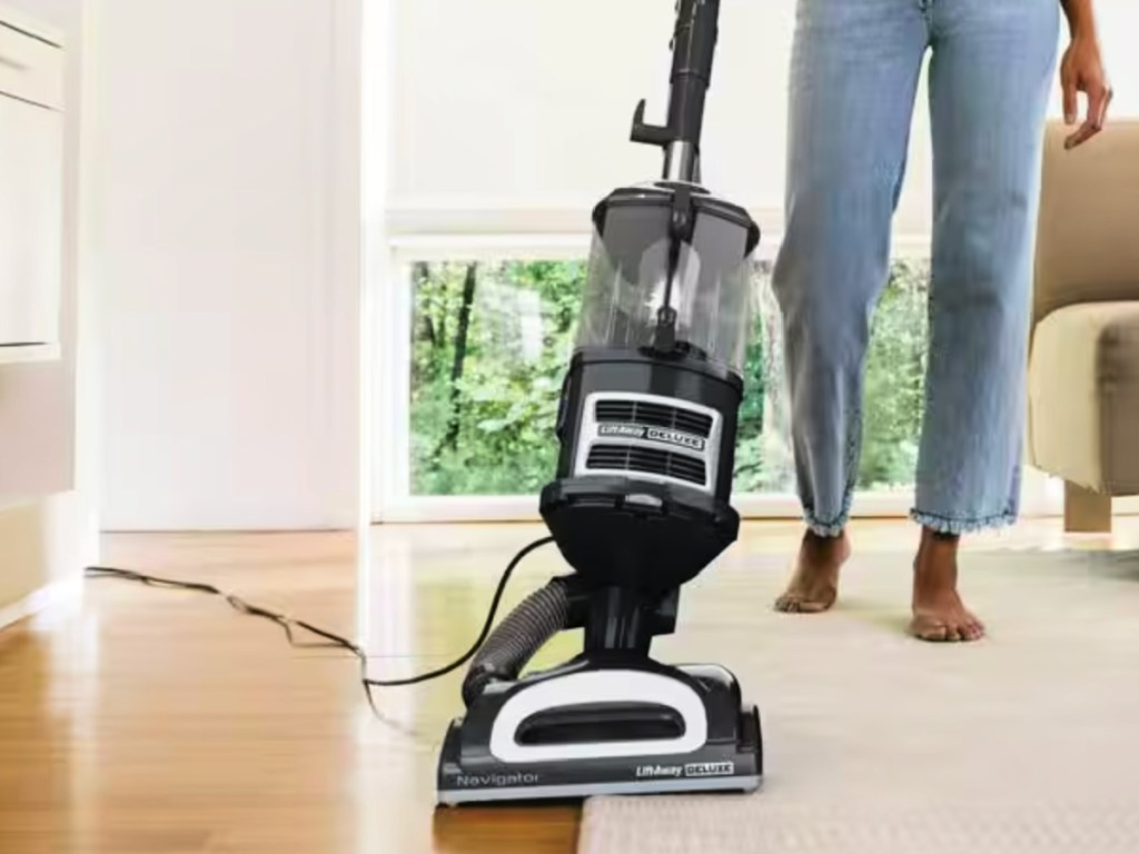 Woman, vacuuming with shark lift away deluxe vacuum