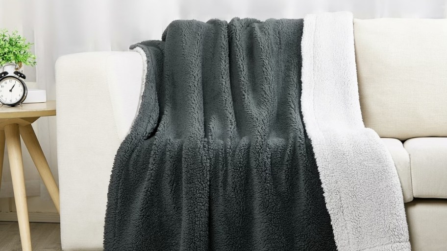 a gray and lite gray sherpa throw draped across a sofa