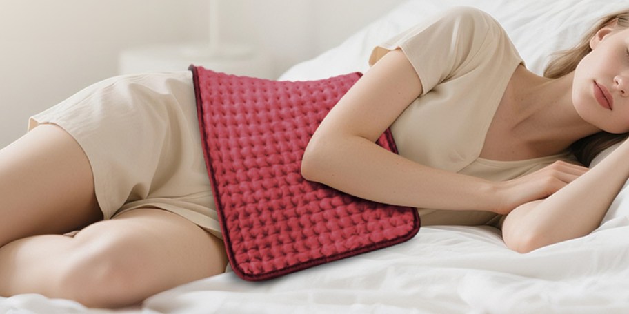 woman laying down with red heating pad 