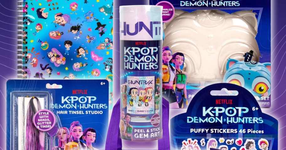 Brightly colored merchandise for "KPOP Demon Hunters," including a notebook, hair tinsel set, gem art, and puffy stickers, featuring animated characters.