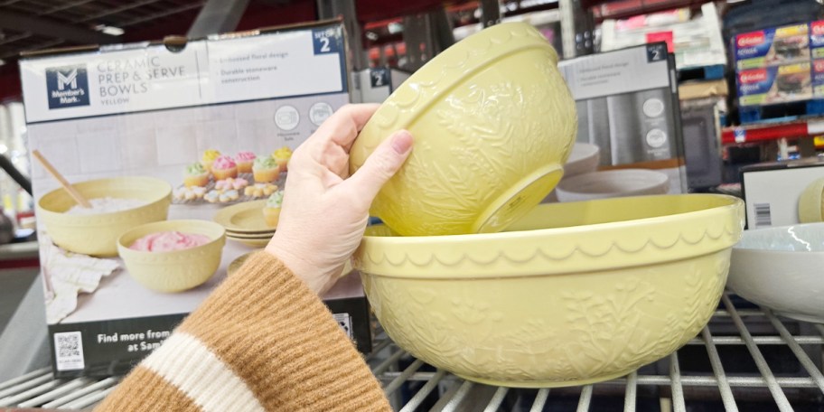 hand reaching for yellow ceramic bowls 