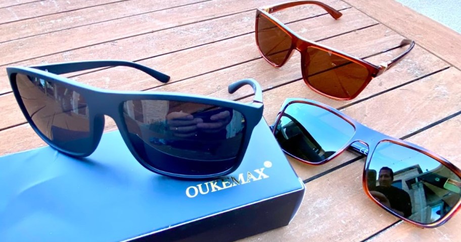 three pairs of sunglasses laying on table