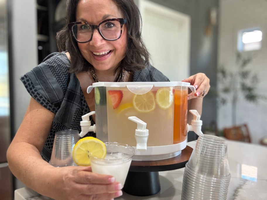 smiling woman standing behind a drink dispenser