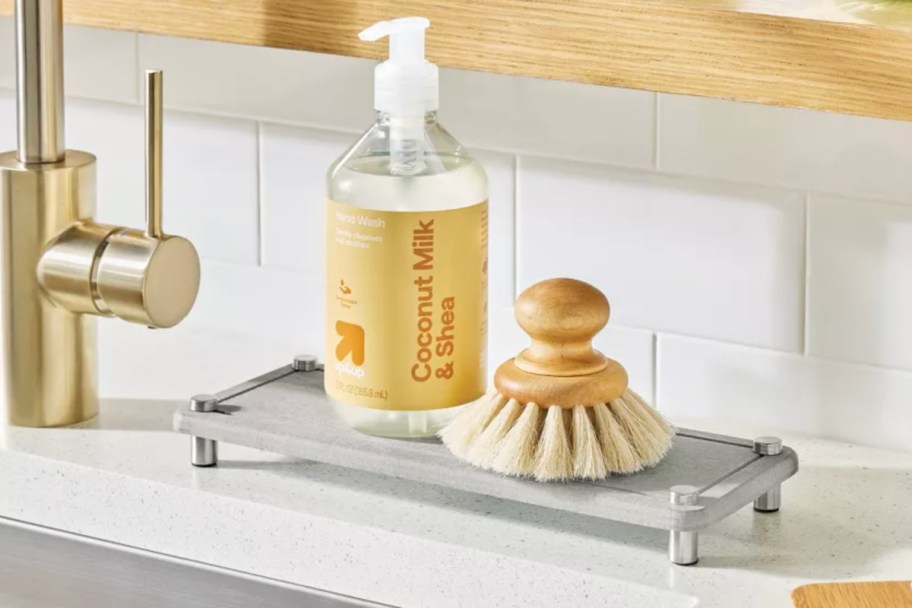 grey mat under soap dispenser and brush