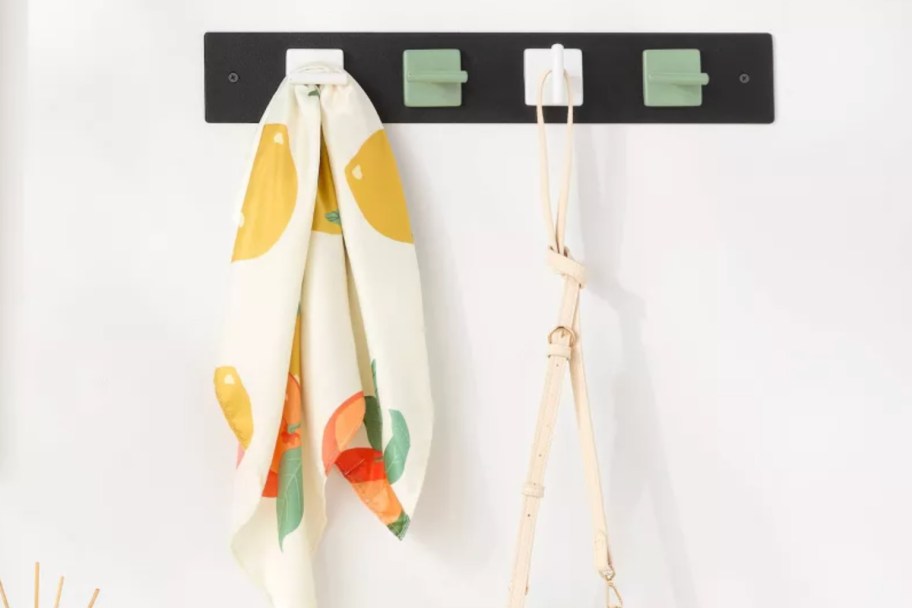 white and green magnetic hooks on black bar