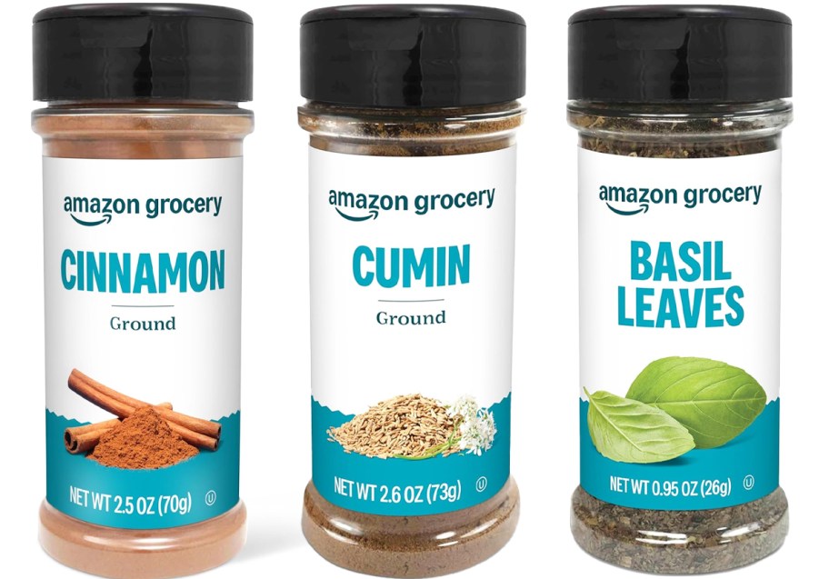 bottles of cinnamon, cumin, and basil leaves