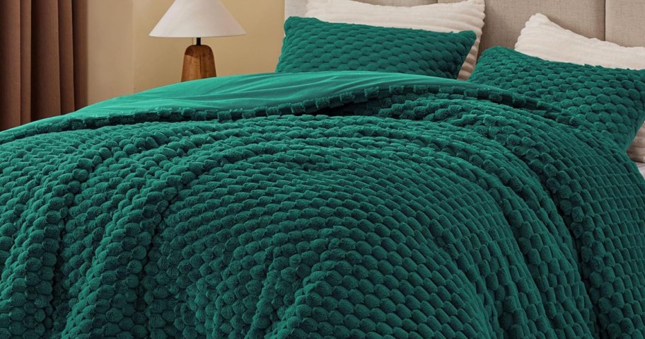 green fuzzy comforter set on a bed