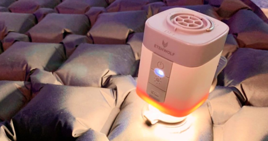 Mini air pump with light on top of gray air mattress