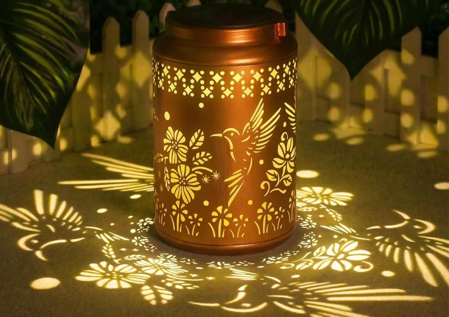 solar lantern casting a hummingbird pattern on table