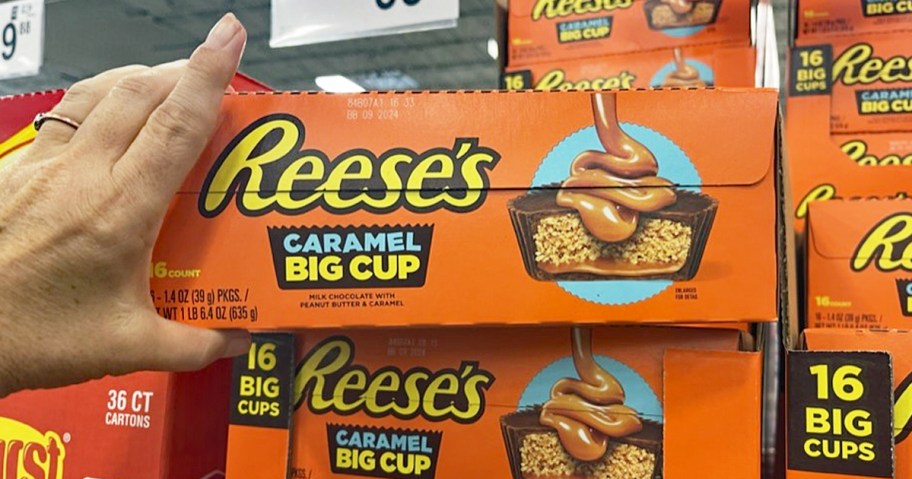 hand holding a large box of Reese's Big Cup Caramel Peanut Butter Cups in store