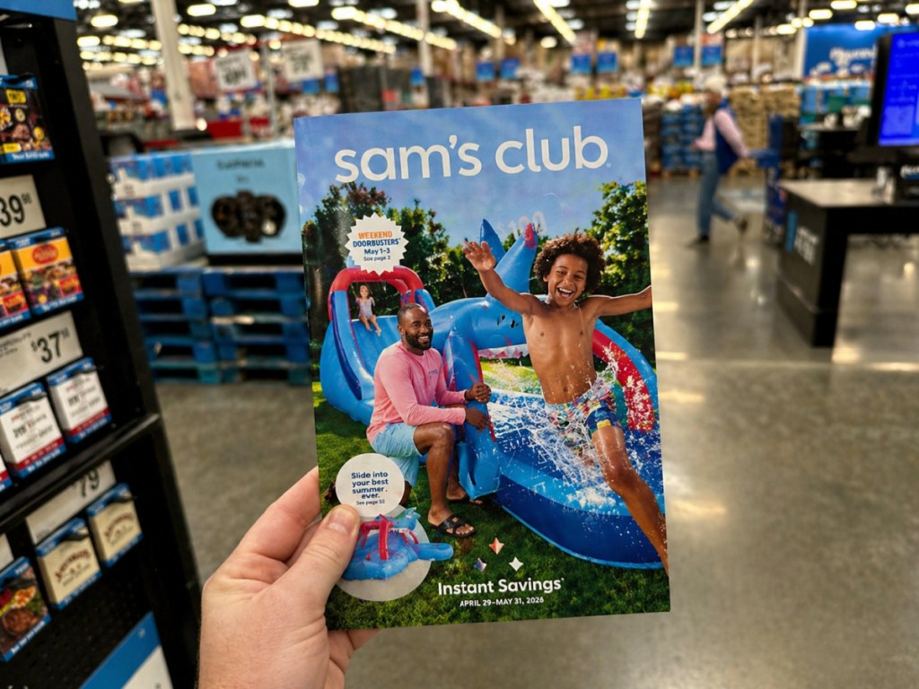 hand holding up Sam's Club instant savings brochure