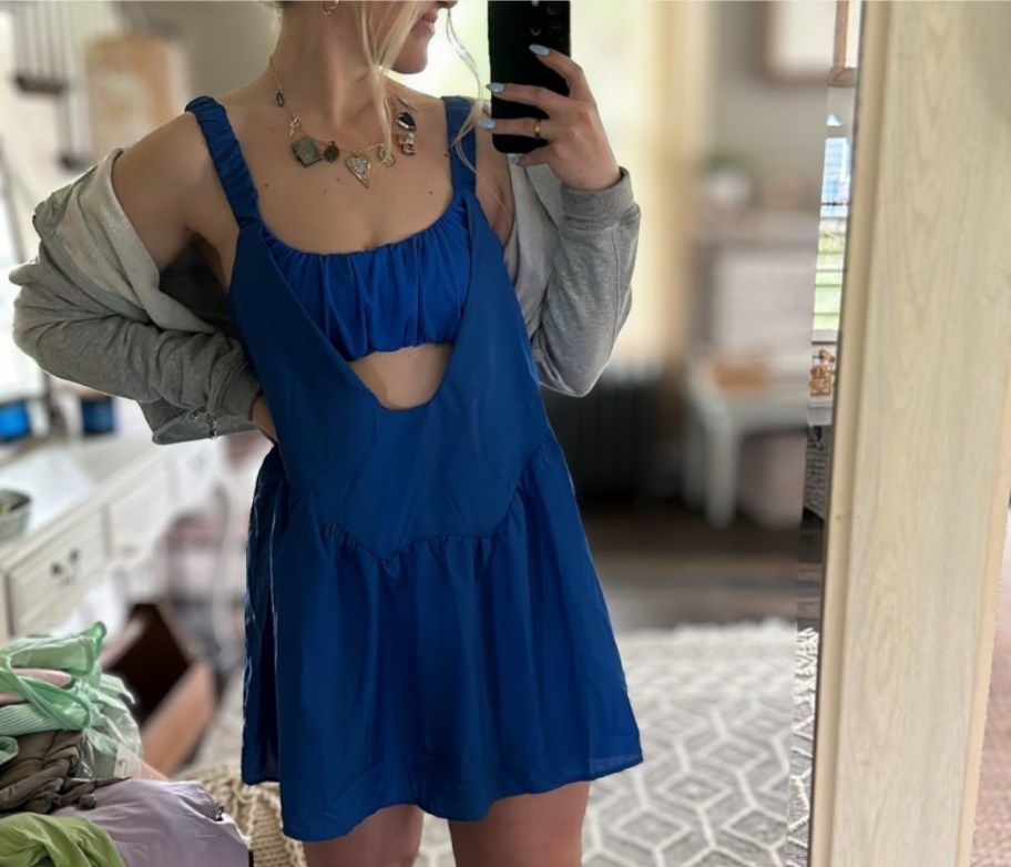 a woman in a blue dress taking a selfie