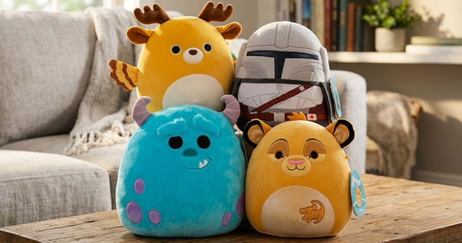 Four plush toys sit on a wooden table in a cozy living room. They resemble a deer, a helmeted figure, a blue creature with horns, and a lion cub.