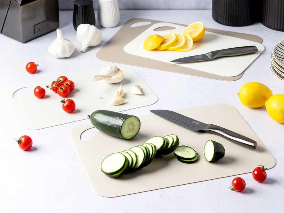 knives and vegetables on top of cutting mats on counter