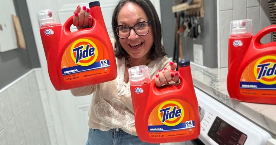 Woman holding large jugs of tide detergent