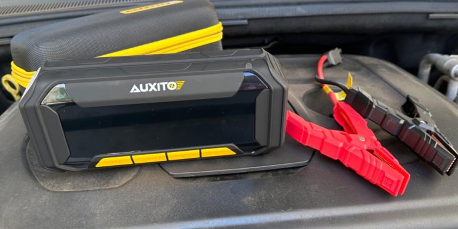 black jumper with cables on car 