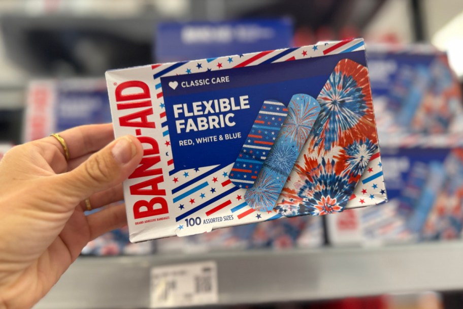 hand holding box of red white and blue bandages