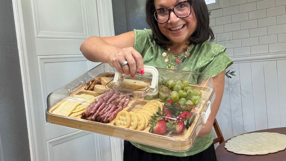 woman holding lid of charcuterie board