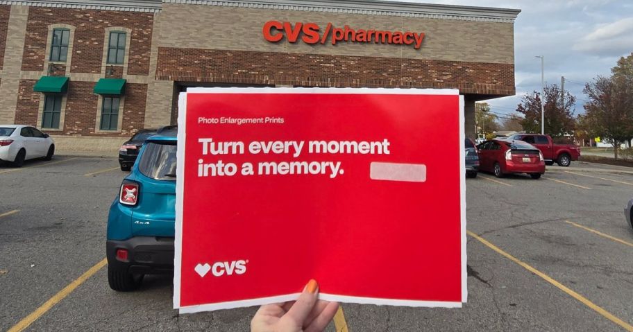 hand holding 8x10 photo holder in front of cvs store