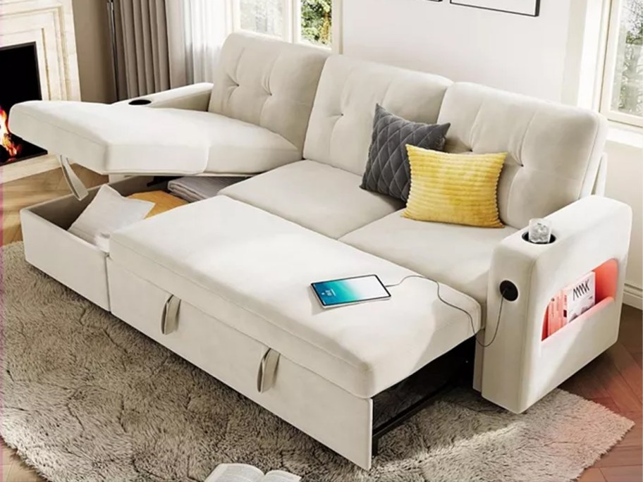 white couch with pillows and tablets on it 