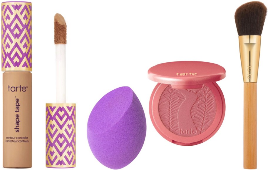 Tarte makeup set includes a Shape Tape concealer with applicator, purple blending sponge, pink blush compact, and a gold-handled makeup brush.