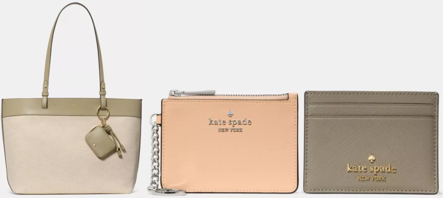 A beige tote bag with khaki accents, a peach zip wallet with silver text, and a gray card holder with gold text, all featuring the Kate Spade logo.