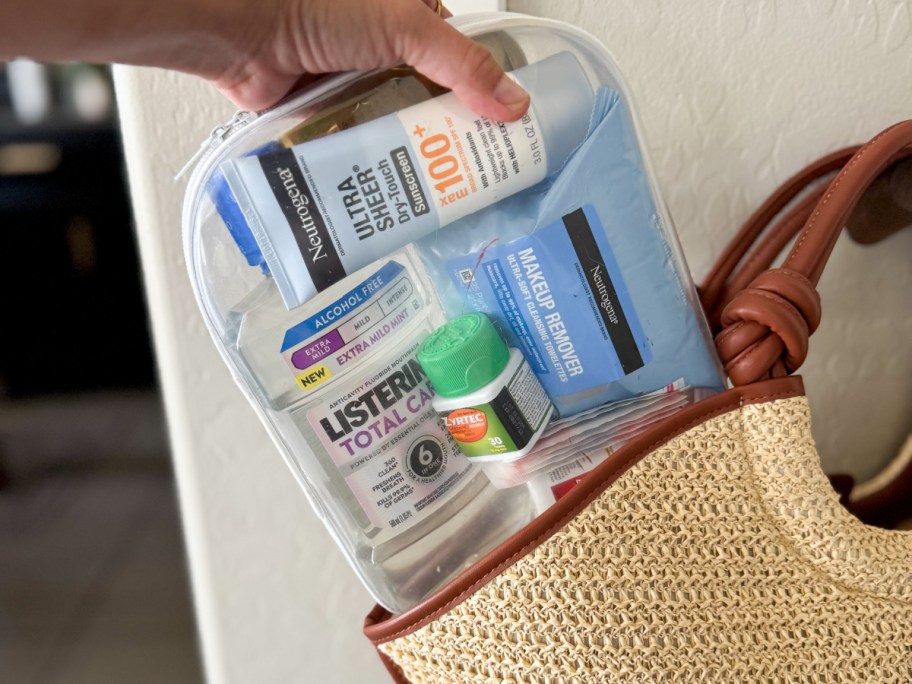 various personal care items in a clear plastic container, being slipped into a tote bag