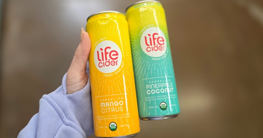 hand holding two cans of Life Cider drinks