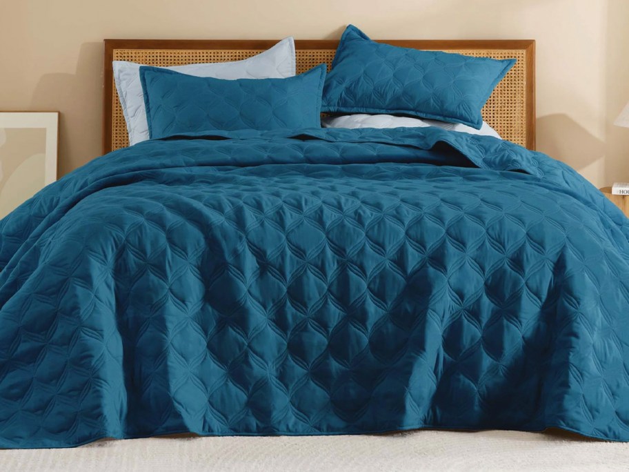 teal quilt set on bed 