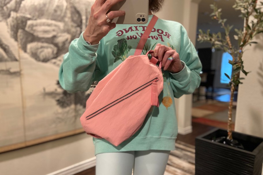 woman wearing a pink lululemon bag like a sling