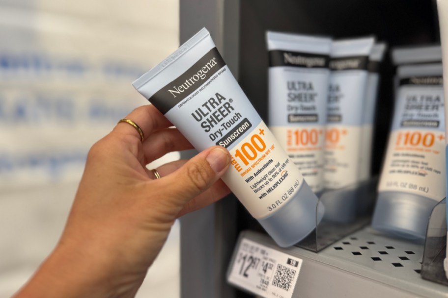 hand grabbing sunscreen off store shelf