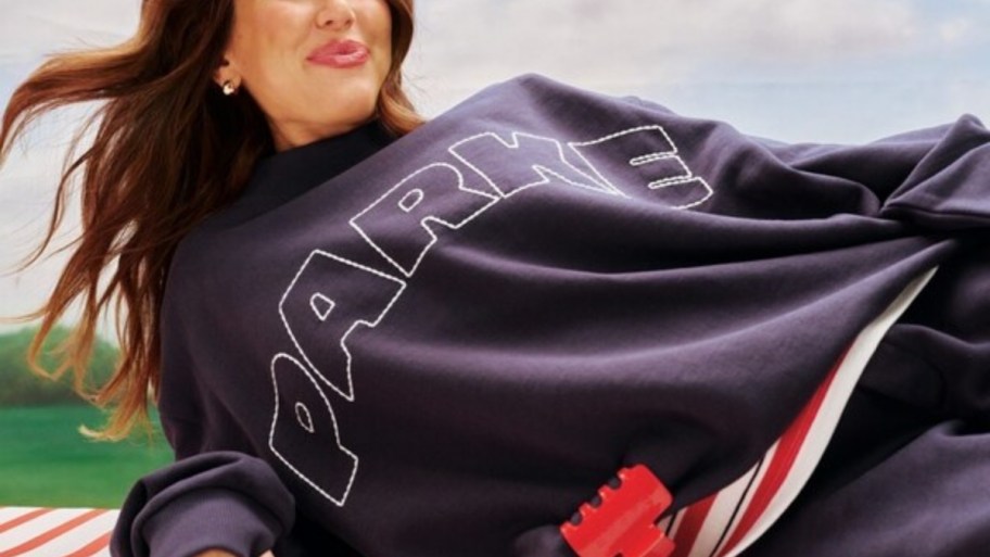 a woman in a parke branded logo sweatshirt